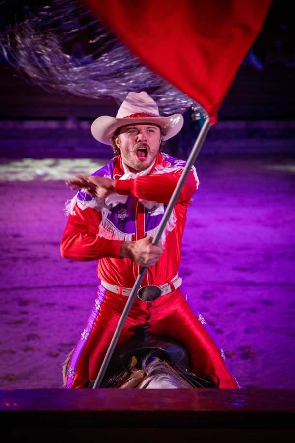 A red rider on horse waves a flag