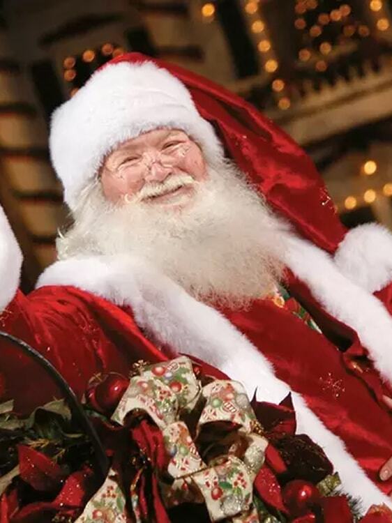 Santa is in the sleigh waving to guests.